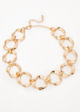 Necklace with twisted rings in gold-tone metal. Lobster-clasp fastening.